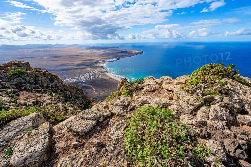 Castillejo viewpoint, view from the Risco de Famara cliffs to the coast and the sea with the Famara beach, Playa de Famara, Lanzarote, Canary Islands, Spain