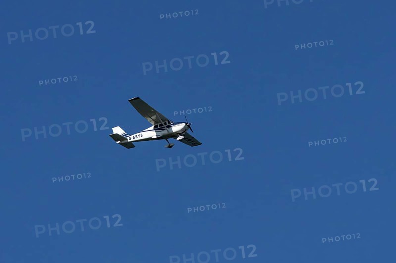 Cessna 172C Skyhawk light aircraft flying in a blue sky, England, United Kingdom