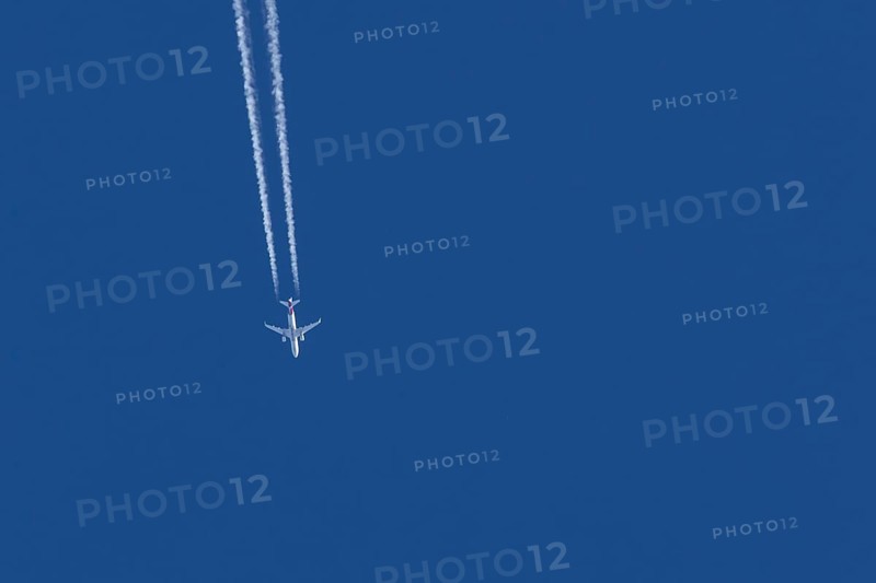 Airbus jet passenger aircraft of Eurowings airlines flying in a blue sky with contrails or vapour trails behind, England, United Kingdom