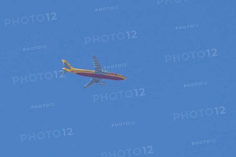 Boeing 767 jet cargo aircraft of DHL airlines flying in a blue sky, England, United Kingdom
