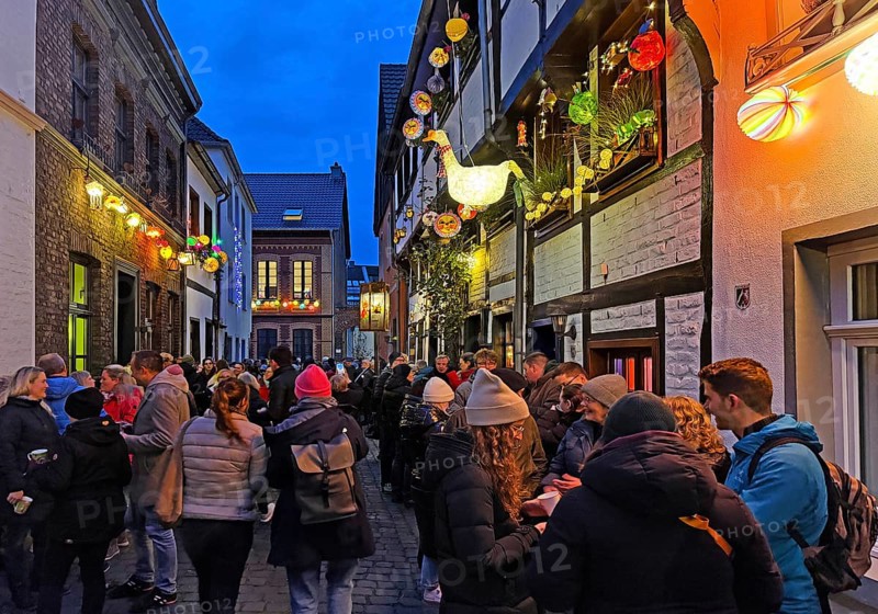 People on the Alte Schulstraße decorated for the Martin train in the evening, Old Town, Kempen, Lower Rhine, North Rhine-Westphalia, Germany