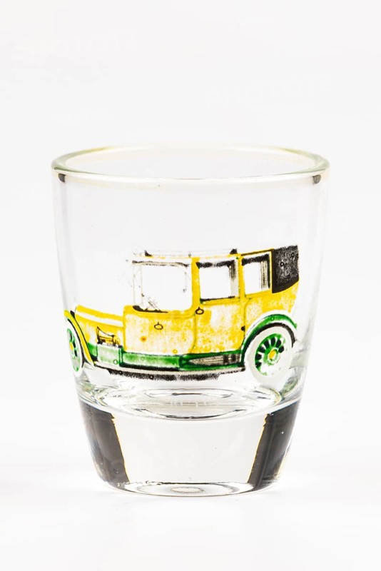 Shot glass with historic car motif, mainly in yellow