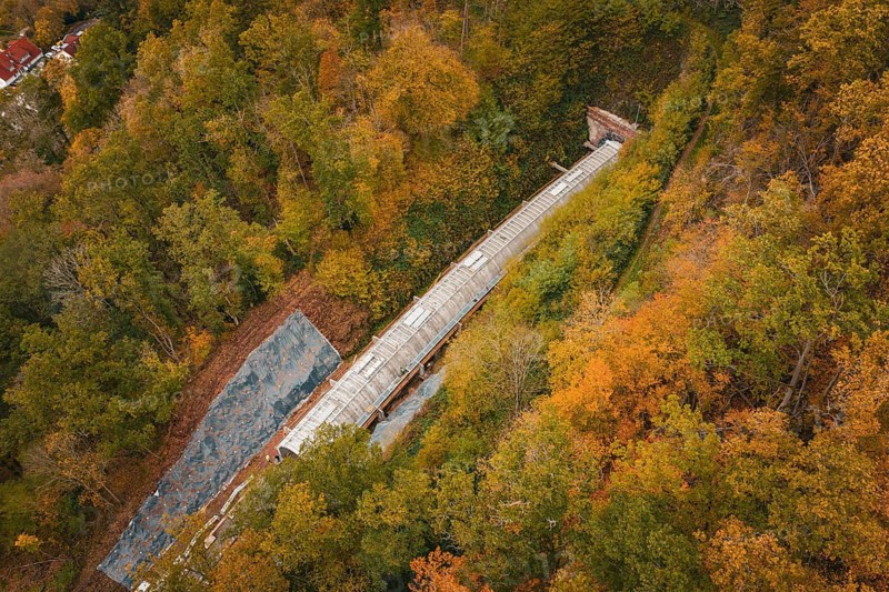 Aerial view of a railway tunnel under construction between autumnal forests, Hermann-Hesse-Bahn construction site, Calw, Germany