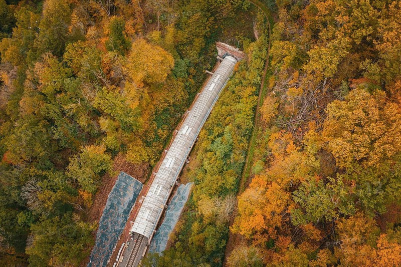 Aerial view of a train tunnel under construction surrounded by autumn trees, Hermann-Hesse-Bahn construction site, Calw, Germany