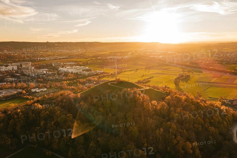 A wide landscape with fields, wind turbine and forest at sunset, Grüner Heiner, Korntal, Germany