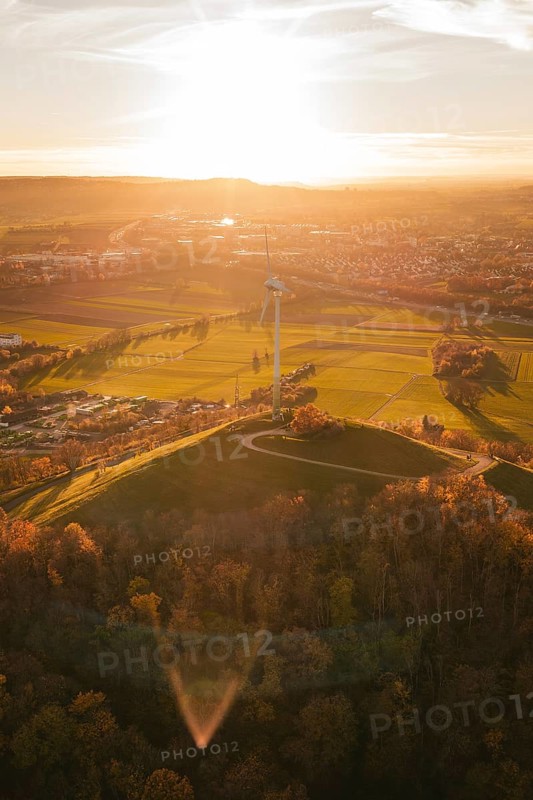 A wind turbine overlooks a vast, autumnal landscape at sunset, Grüner Heiner, Korntal, Germany