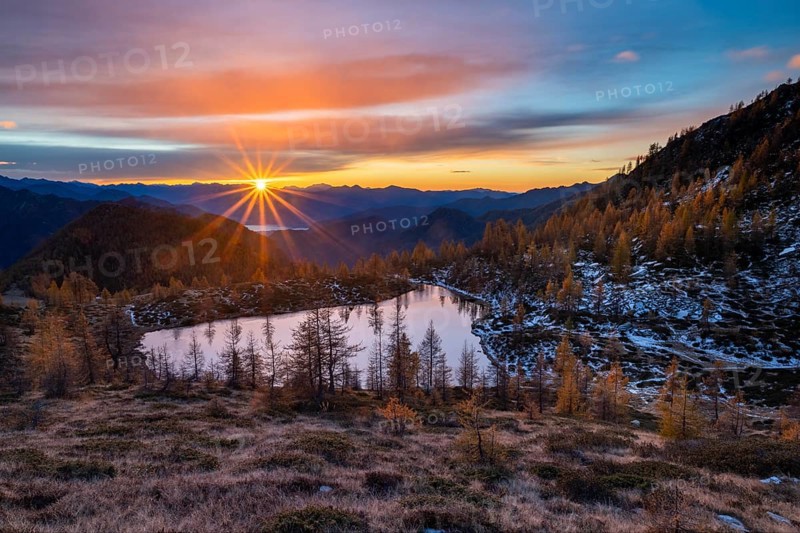 Laghetto dei Saléi mountain lake with autumnal larches (Larix) at sunrise, Onsernone Valley, Canton of Tessin, Switzerland