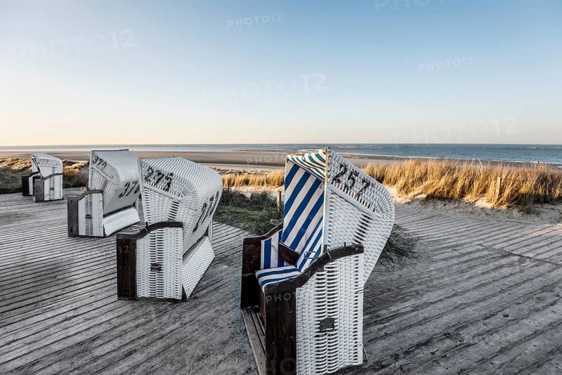 Beach chairs in the dunes and blue sky in winter, sunset, Spiekeroog, East Frisian Islands, Lower Saxony, Germany
