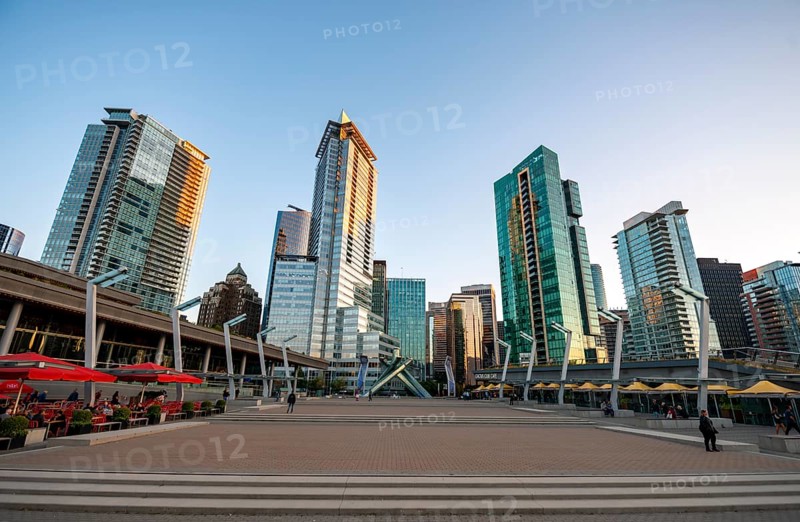 Olympic Cauldron Statue, Jack Poole Plaza Square, skyscrapers on the promenade at sunset, Coal Harbour, Vancouver, British Columbia, Canada