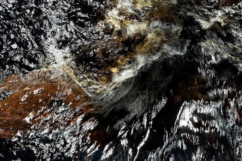 Stream flow with dark water, reflections and turbulences, long exposure, Sweden