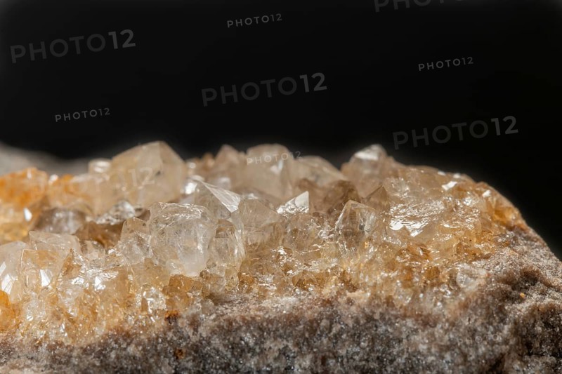 Shiny quartz crystals are visible on rock surface. The sparkle of the crystals and the texture of the rock create a mesmerizing scene with soft lighting. Bas Rhin, Alsace, France