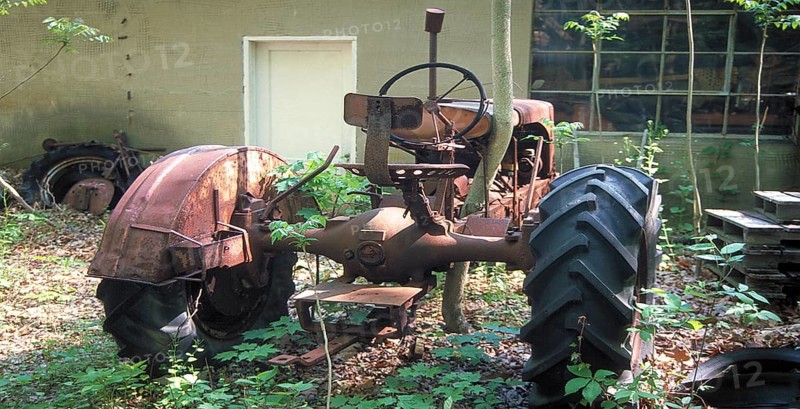 Rusted tractor at a car cemetery in a forest, Marksboro, New Jersey, USA