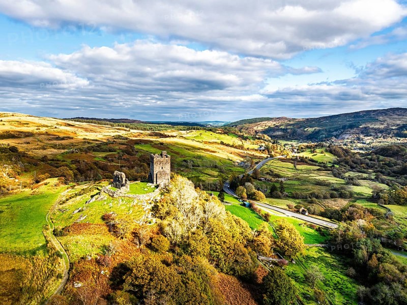 Autumn colours over Castell Dolwyddelan and Eryri Mountains from a drone, Snowdonia, Conwy County Borough, Wales, England, United Kingdom