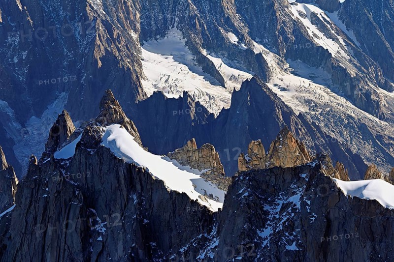 Rugged rocks jut out of a snow-covered mountain, viewing platform, Aiguille du Midi mountain station, Chamonix-Mont-Blanc, Haute-Savoie, France