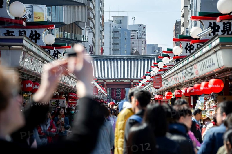 View of numerous visitors on Nakamise-dori shopping street at the Thunder Gate Kaminarimon of Asakusa Shrine or Senso-ji Temple, blooming cherry trees, Buddhist temple complex, Asakusa, Tokyo, Japan