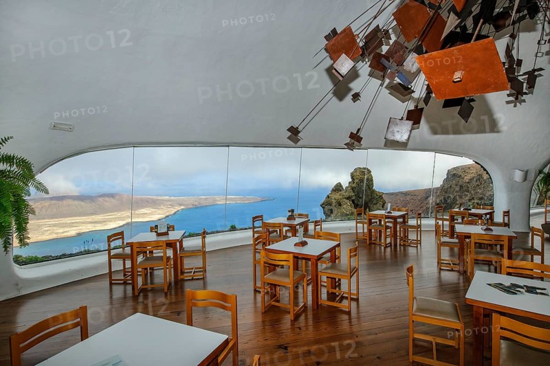 Interior of café with panoramic window in building designed by Cesar Manrique with the collaboration of Jesús Soto and architect Eduardo Caceres without right angles corners on viewpoint tourist attraction El Mirador del Río on the summit of the 474 meter high Risco de Famara in Famaramassiv with panoramic view of the Chinijo Archipelago, La Graciosa island, Lanzarote, Canary Islands, Canary Islands, Spain