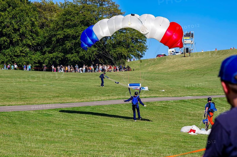 Landing of skydivers during an aerial acrobatic performance as part of an air show at the Rossfeld Air Sports Association Air Sports Festival on Rossfeld in Metzingen-Glems, Baden-Württemberg, Germany, for editorial use only