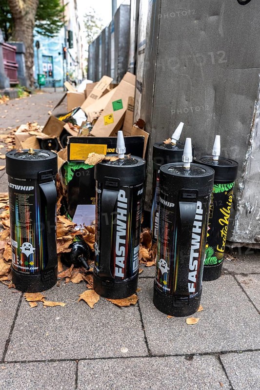 Empty cartridges filled with N2O, nitrous oxide gas, called laughing gas, officially it serves as a propellant to produce whipped cream in appropriate devices, but is often used as an intoxicant, party drug, misused, here mass, illegal disposal in addition to waste paper containers in Düsseldorf, North Rhine-Westphalia, Germany