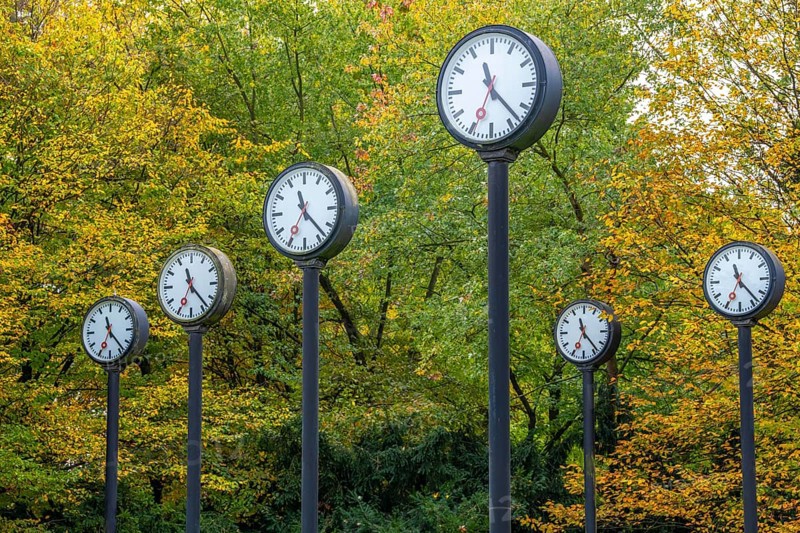 The art installation Zeitfeld in Volksgarten Park in Düsseldorf-Oberbilk, a total of 24 station clocks, on 6 meter high steel columns, have been running synchronously since 1987, artwork by Düsseldorf artist Klaus Rinke, symbol of time, time change, North Rhine-Westphalia, Germany