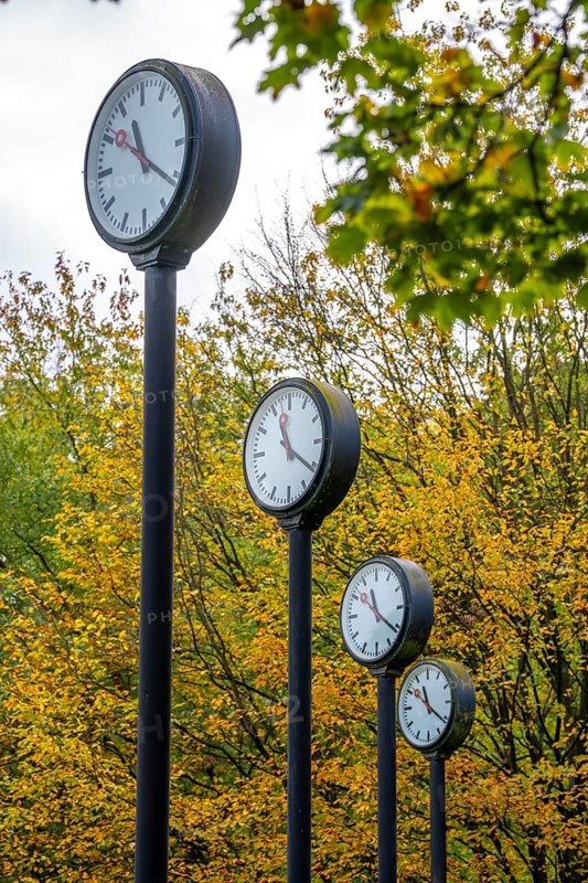 The art installation Zeitfeld in Volksgarten Park in Düsseldorf-Oberbilk, a total of 24 station clocks, on 6 meter high steel columns, have been running synchronously since 1987, artwork by Düsseldorf artist Klaus Rinke, symbol of time, time change, North Rhine-Westphalia, Germany