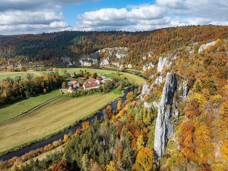 Aerial view of Käppeler Manor with St. George's Basilica near Thiergarten in the Upper Danube Valley, surrounded by autumn vegetation, on the right the raven rocks, climbing rocks, Jura limestone rocks, Sigmaringen district, Baden-Württemberg, Germany