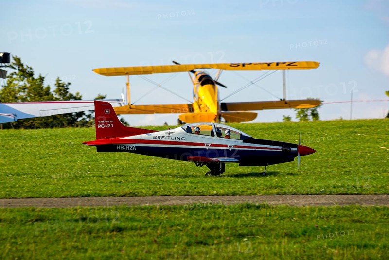 An RC model of a Pilatus PC-21 with advertising for the Swiss watch brand Breitling during a flight demonstration as part of an air show at the Rossfeld in Metzingen-Glems, Baden-Württemberg, Germany, for editorial use only