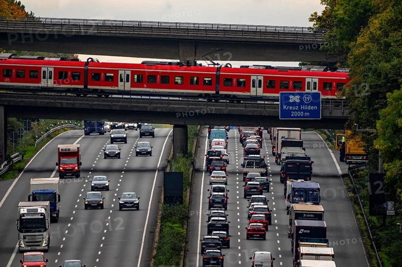 Local train crossing the A3 motorway between the Hilden junction and the Mettmann junction, view to the south, traffic jam due to construction work, North Rhine-Westphalia, Germany