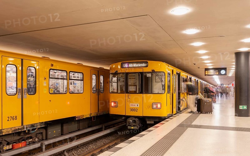 Dynamic scene of a Berlin underground in typical yellow colour, long exposure with blur effect, busy traffic junction at Unter den Linden station, Berlin, Germany