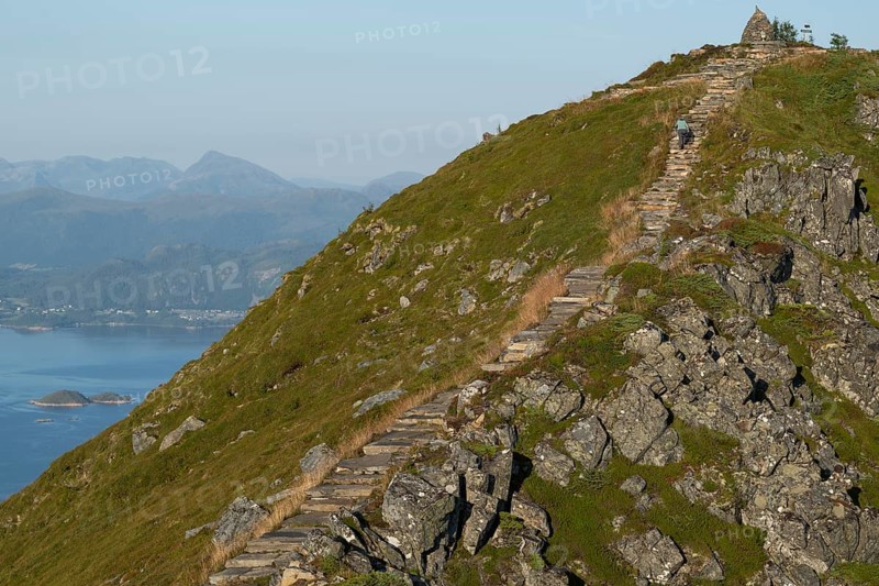 Woman with hiking poles walking up Rørsethornet stone stairs, with 3292 steps one of the longest continuous stone stairs in the world, Sherpat stairs or Midsund stairs or Midsundtrappene, Rørsethornet hike, Otroya or Otrøya island, Møre og Romsdal, Norway