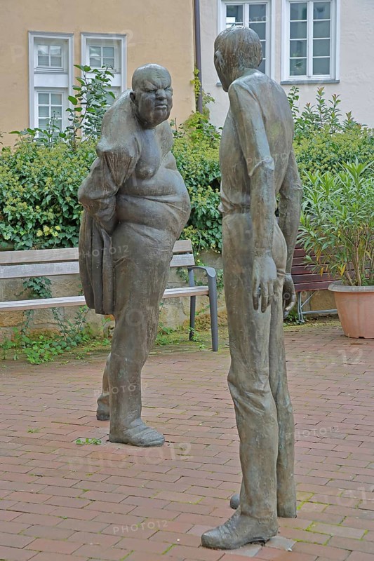 Sculpture Confrontation by Karl-Henning Seemann 1979, two bronze sculptures, modern art, male figures, life-size, social non-verbal communication, fierce facial expression, evil eye, interaction, gesture, emotion, posture, conflict, dispute, quarrel, argument, grim, angry, furious, serious, look, Am Markt, Tübingen, Neckartal, Baden-Württemberg, Germany