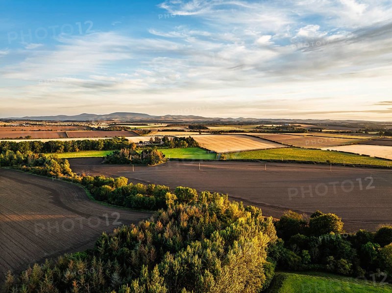 Sunset of Farms and Fields over Norham Castle from a drone, Norham, River Tweed, Northumberland, England, United Kingdom