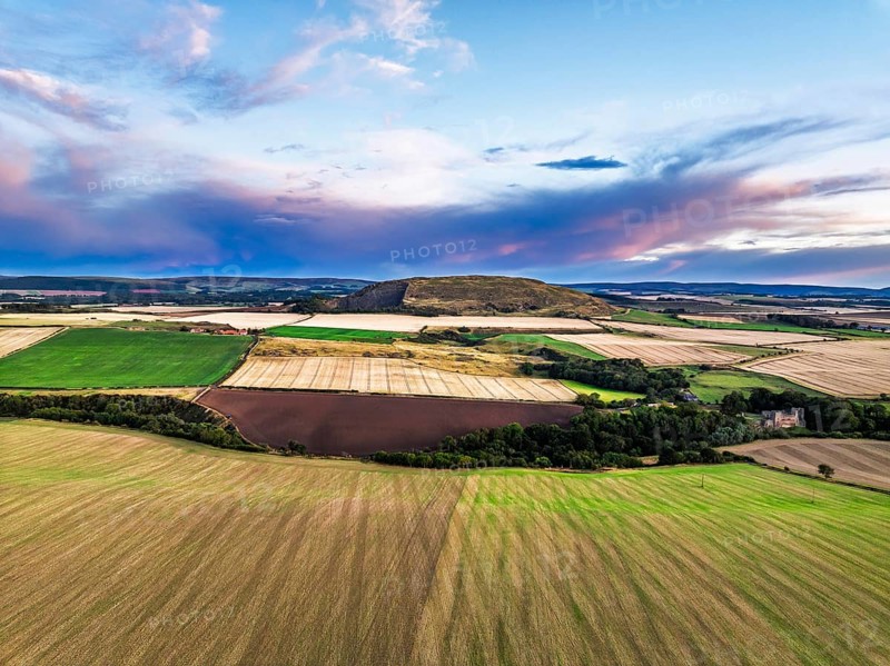 Sunset of Fields and Farms over Traprain Law and Hailes Castle from a drone, River Tyne, Haddington, East Lothian, Scotland, UK