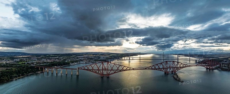 Sunset Panorama of Rain clouds over Forth Bridge from a drone, Queensferry Crossing, Forth Estuary, Scotland, United Kingdom