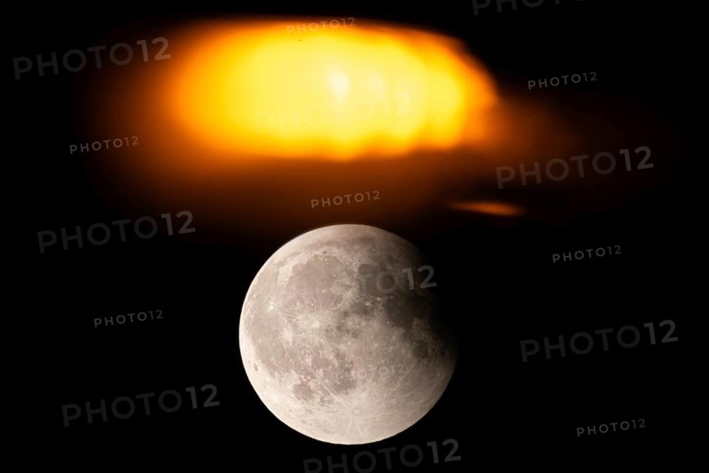 After a total lunar eclipse, the moon appears shortly after its rise in the evening sky as a so-called blood moon in front of it then begins to emerge from the Earth's umbra, Frankfurt am Main, Hesse, Germany