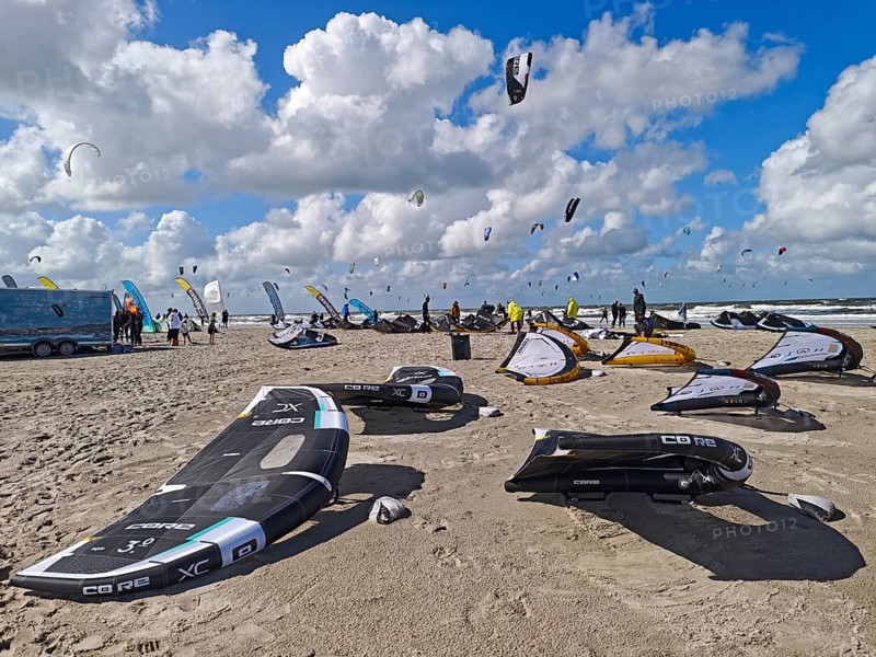 California kitesurfing Masters 2025, kitesurfing on the North Sea beach on the edge of the UNESCO World Heritage Wadden Sea, surfboards, sports competition, flags, strong wind, high swell, whitecaps, summer, sun, blue sky, white clouds, Ording, Sankt Peter-Ording, Schleswig-Holstein, Germany