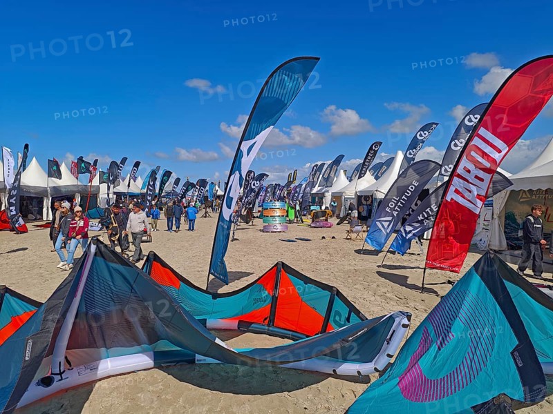 California kitesurfing Masters 2025, Kite Village tents with kite equipment for sale, marketplace, try out, kitesurfing on the North Sea beach, blue sky, sun, summer, Ording, Sankt Peter-Ording, Schleswig-Holstein, Germany