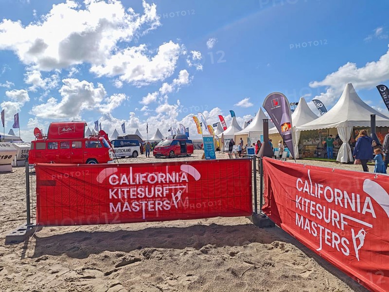 California kitesurfing Masters 2025, Kite Village tents with kite equipment for sale, marketplace, trying out, kitesurfing on the North Sea beach, blue sky, sun, summer, Volkswagen, camper vans, Ording, Sankt Peter-Ording, Schleswig-Holstein, Germany