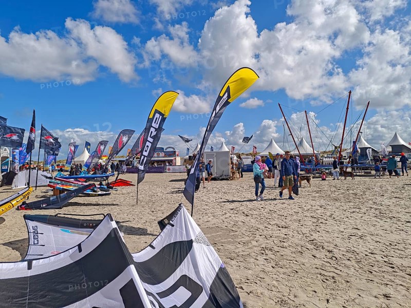 California kitesurfing Masters 2025, Kite Village tents with kite equipment for sale, marketplace, try out, kitesurfing on the North Sea beach, blue sky, sun, summer, trampoline, Ording, Sankt Peter-Ording, Schleswig-Holstein, Germany