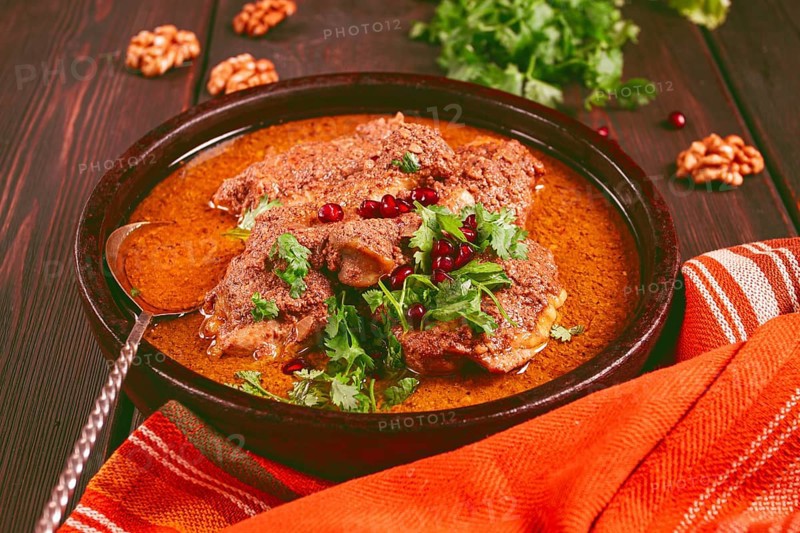 Fesenjan, an Iranian dish, stewed chicken, in walnut-pomegranate sauce, in an earthen pan, homemade, no people
