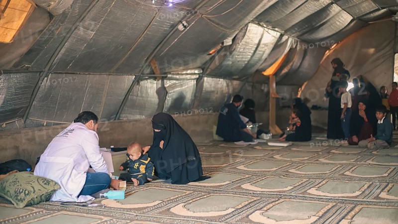 A doctor examining a woman inside a mobile medical point dedicated to treating Syrian refugees. Aleppo, Syria May 28, 2022, Aleppo, Syria