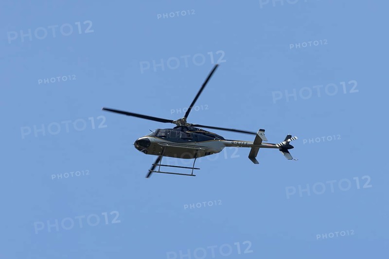 Bell 407GXP jet ranger helicopter flying in a blue sky, England, United Kingdom