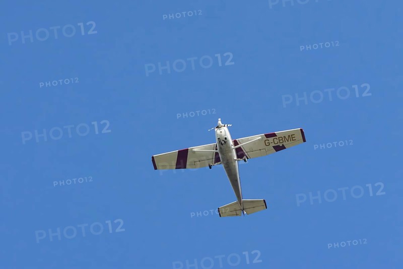 Reims Cessna F172M Skyhawk light aircraft flying in a blue sky, England, United Kingdom