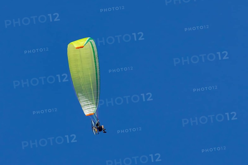 Paraglider flying in a blue sky, England, United Kingdom
