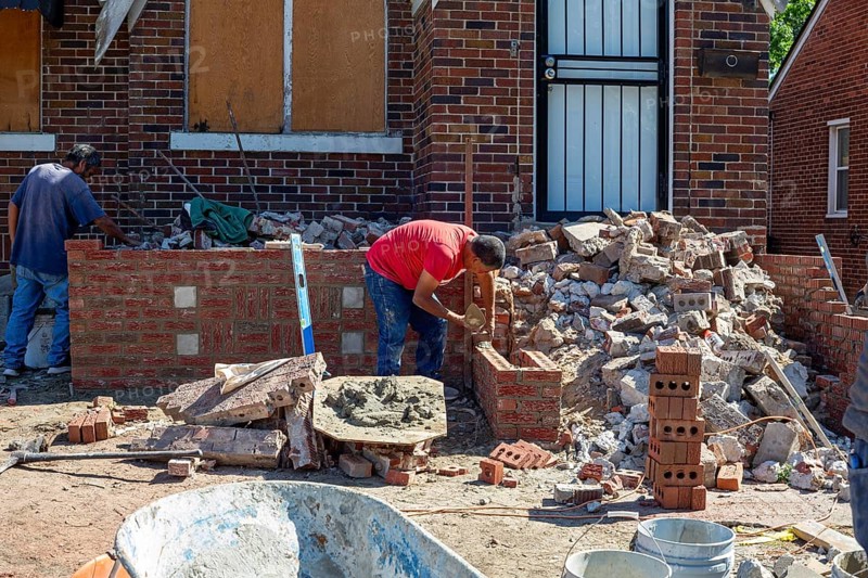 Detroit, Michigan - Workers rebuild the front porch of a house they are remodeling in the Morningside neighborhood. The house had been vacant for many years. Detroit lost nearly two-thirds of its residents from 1950 to 2020 but has been growing modestly in recent years