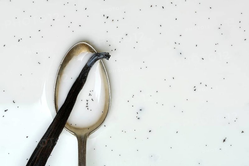 Spoon with vanilla pod, vanilla seeds in milk