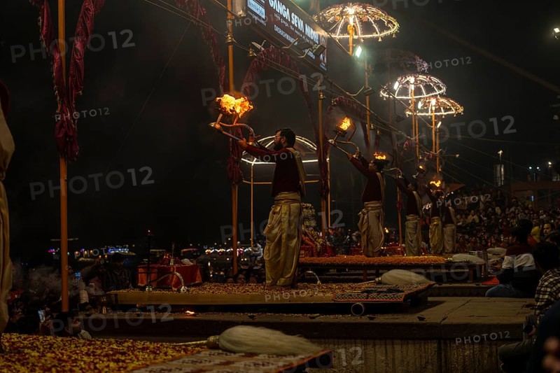 Hindu priest performing the Aarti ritual, holding a burning oil lamp, at the Ganges, Bangali Tola, Varanasi, Uttar Pradesh, India
