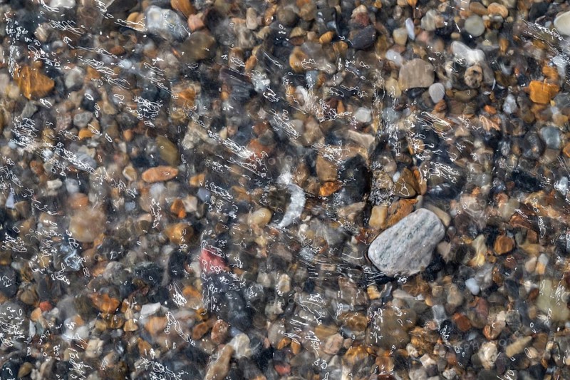 Colourful, smooth pebbles under a clear water surface, North Sea, Denmark