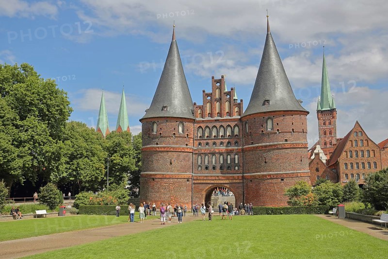 Historic Holsten Gate and pedestrians, tourists, St. Mary's Church, Lübeck St. Peter's Church Tower, Brick Gothic, brick buildings, towers, city gate, landmark, Holsten Gate Square, Old Town, Lübeck, Schleswig-Holstein, Germany