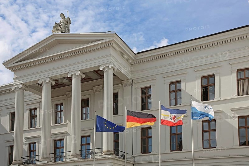Portal with columns and EU flag, German national flag and Mecklenburg-Vorpommern state flag on the classicist government building, state chancellery, college building, white palace, Schwerin, Mecklenburg-Vorpommern, Germany
