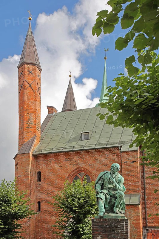 Monument to the writer and poet Emanuel Geibel by Hermann Volz 1889 and Heiligen-Geist-Hospital, brick building, bronze sculpture, Grünspan, Geibelplatz, Old Town, Lübeck, Schleswig-Holstein, Germany